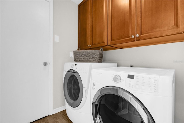 laundry area with dark wood-style floors, baseboards, cabinet space, and washer and dryer