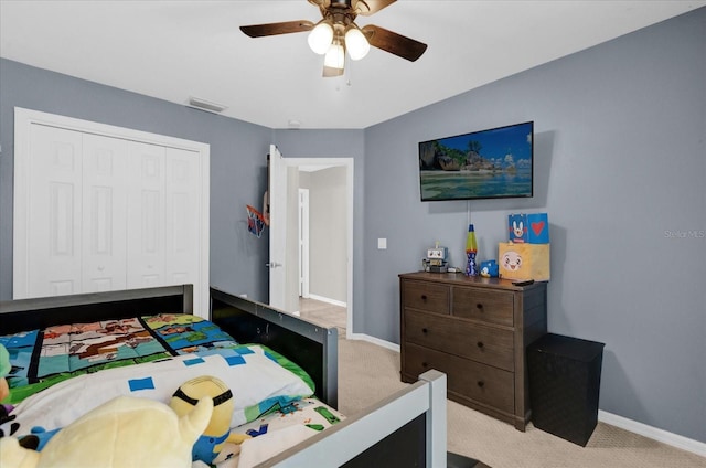 bedroom with light colored carpet, a ceiling fan, baseboards, visible vents, and a closet