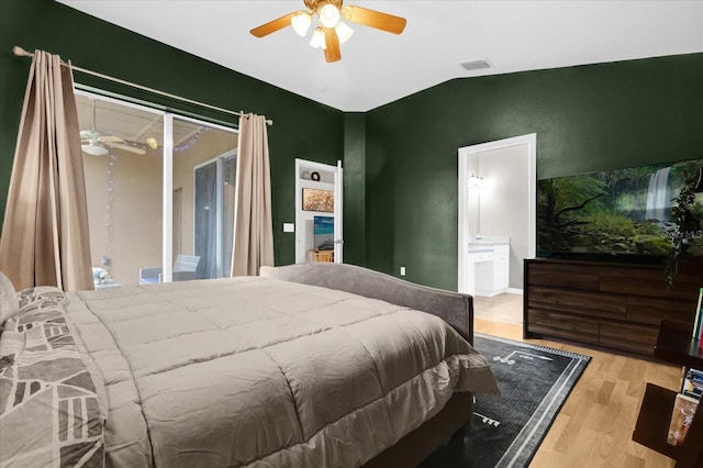 bedroom with access to exterior, lofted ceiling, visible vents, ensuite bathroom, and wood finished floors