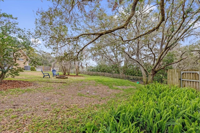 view of yard featuring a fire pit and fence