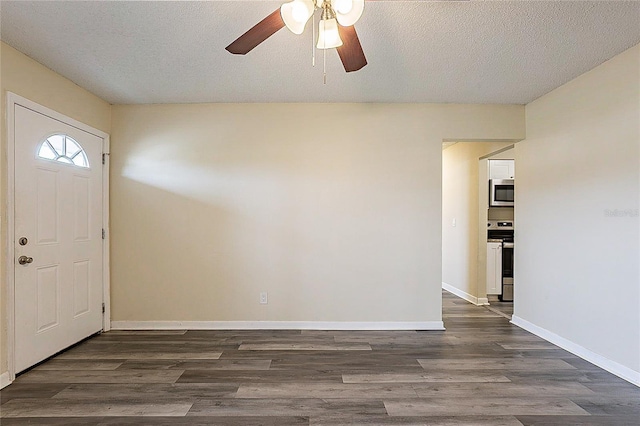 foyer entrance with ceiling fan, a textured ceiling, baseboards, and dark wood-style flooring