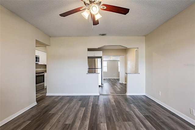 unfurnished room featuring dark wood-type flooring, ceiling fan, a textured ceiling, and baseboards