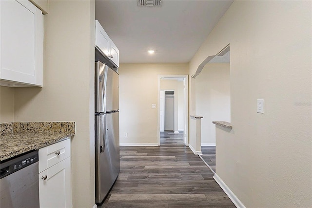 kitchen with white cabinets, dark wood-style floors, baseboards, and stainless steel appliances