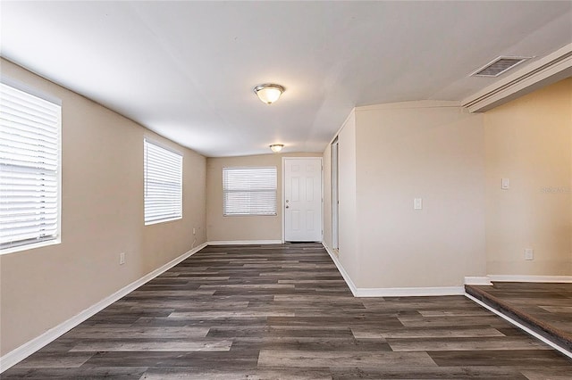 entryway with dark wood-type flooring, visible vents, and baseboards