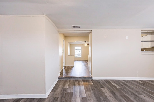 hall featuring wood finished floors, visible vents, and baseboards