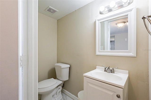 half bath with visible vents, vanity, toilet, and baseboards