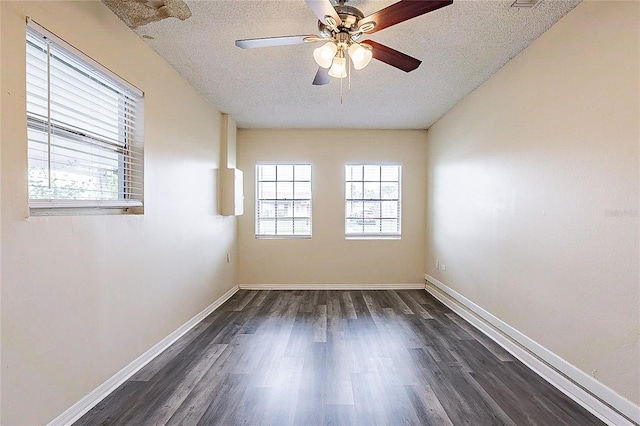 spare room featuring a ceiling fan, dark wood finished floors, a textured ceiling, and baseboards