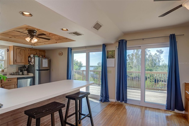 kitchen featuring visible vents, appliances with stainless steel finishes, light countertops, and a tray ceiling