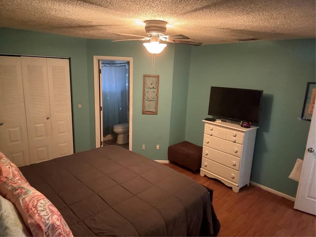 bedroom with visible vents, a textured ceiling, wood finished floors, a closet, and baseboards