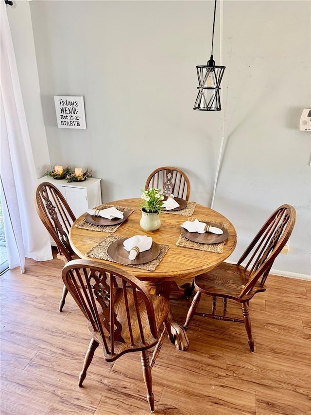 dining area featuring light wood-style flooring and baseboards