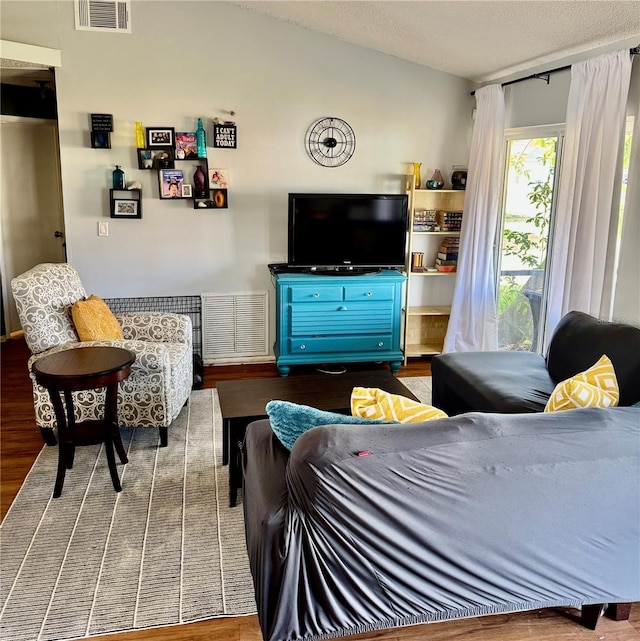 living room featuring a textured ceiling, wood finished floors, and visible vents