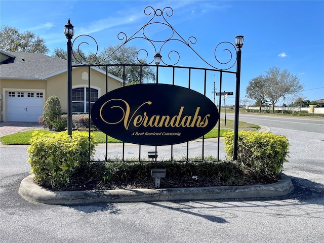 community sign with a garage and driveway