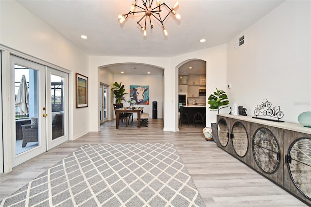 interior space featuring arched walkways, french doors, recessed lighting, visible vents, and light wood-type flooring