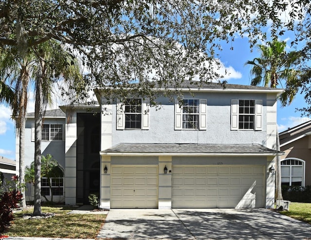 traditional home with stucco siding, concrete driveway, and an attached garage