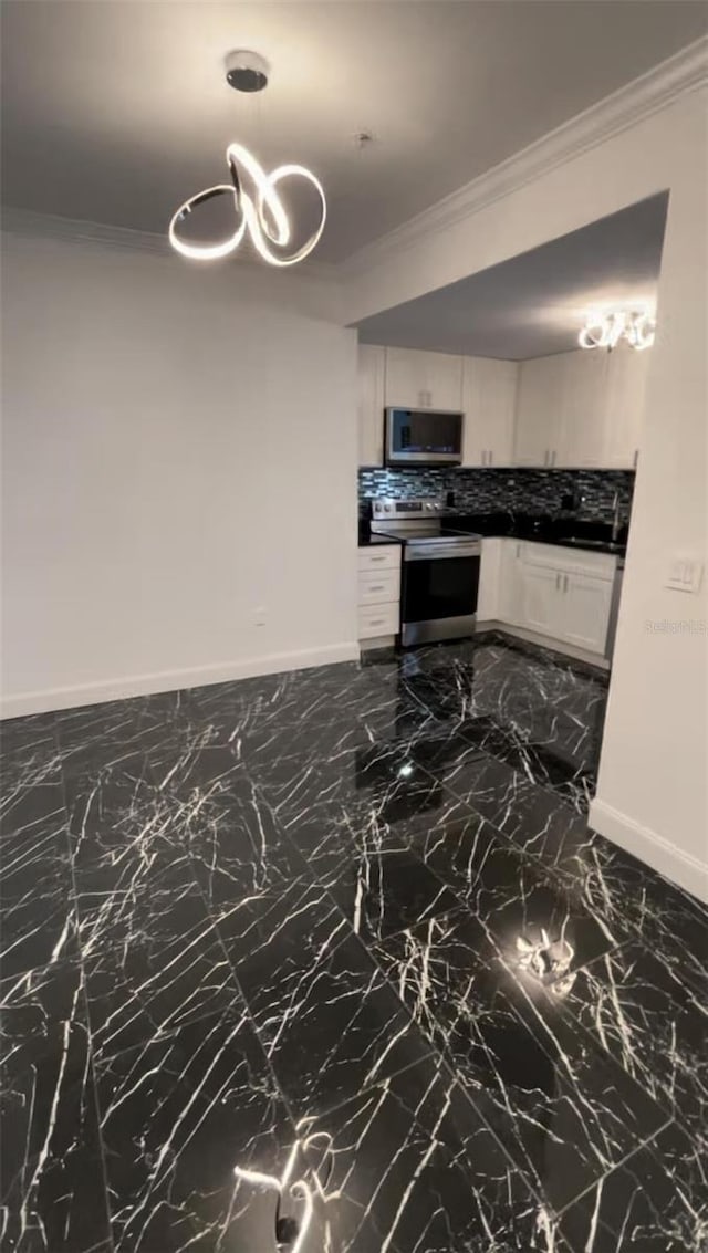 kitchen featuring white cabinetry, marble finish floor, appliances with stainless steel finishes, tasteful backsplash, and crown molding