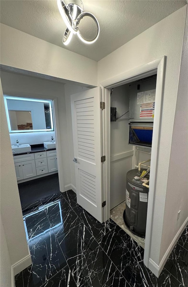 bathroom with a textured ceiling, marble finish floor, visible vents, and baseboards