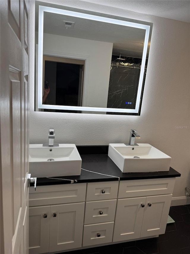 bathroom featuring double vanity, a sink, and visible vents