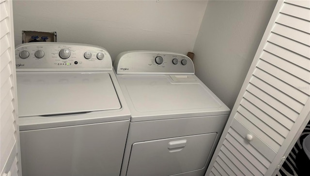 clothes washing area featuring laundry area and washer and clothes dryer