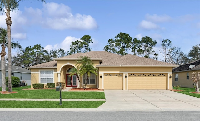 view of front of house with a garage, concrete driveway, a front lawn, and stucco siding