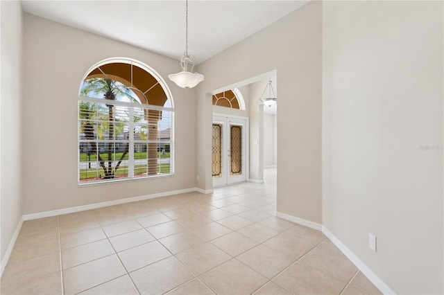 unfurnished room with light tile patterned floors, baseboards, and french doors