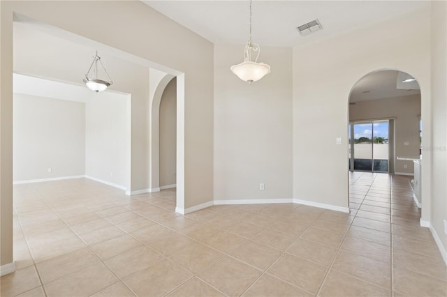 unfurnished room featuring arched walkways, visible vents, baseboards, and light tile patterned floors