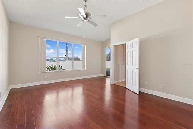 interior space with ceiling fan, vaulted ceiling, baseboards, and wood finished floors