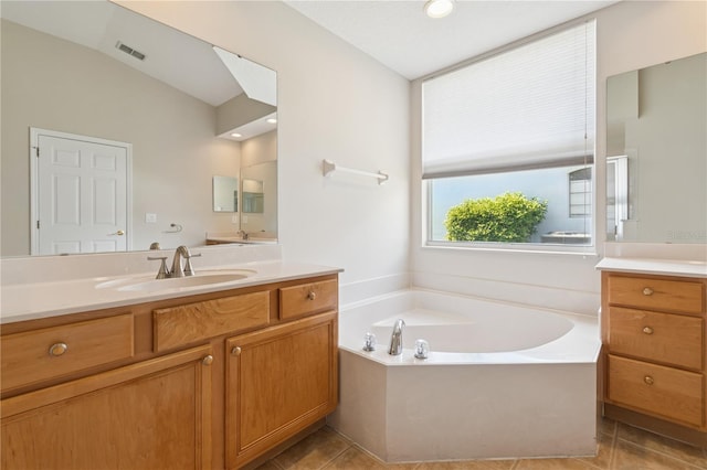 bathroom with tile patterned flooring, visible vents, vanity, and a bath