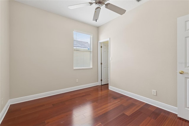 empty room featuring dark wood-type flooring, baseboards, and a ceiling fan