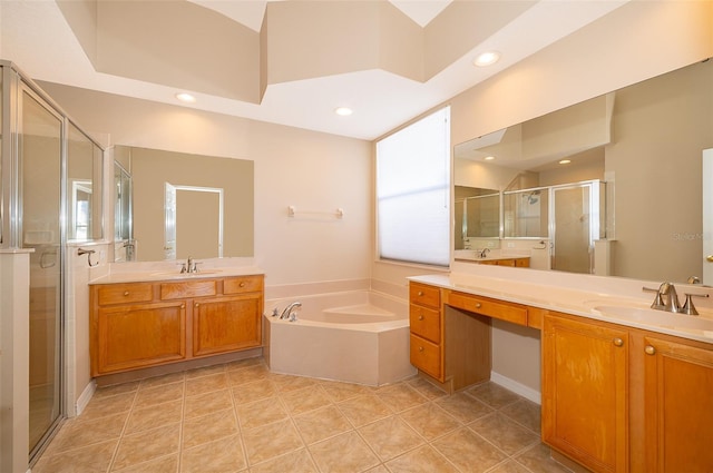 full bathroom featuring a stall shower, two vanities, a garden tub, and a sink