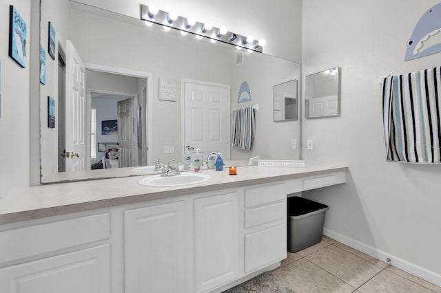 ensuite bathroom with ensuite bathroom, baseboards, vanity, and tile patterned floors