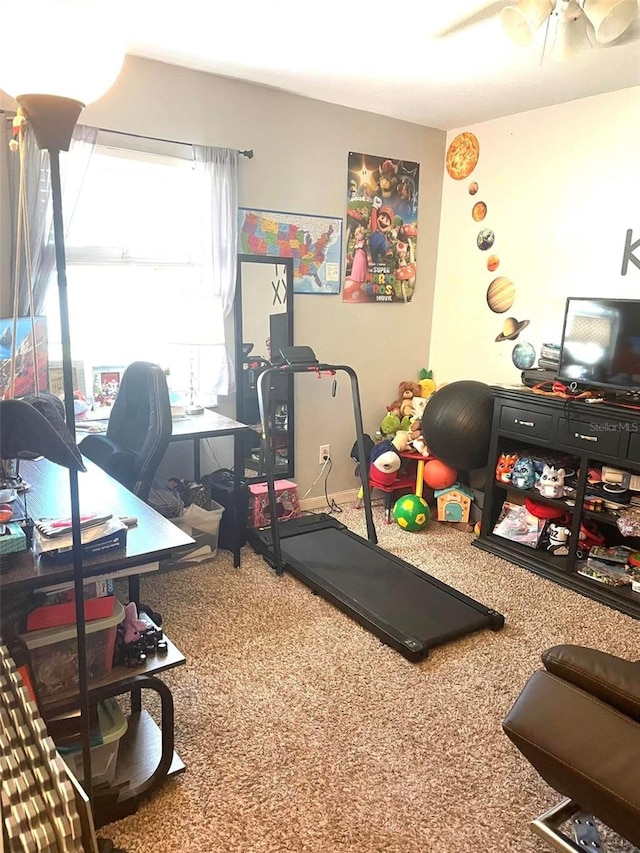 exercise room with a ceiling fan and carpet flooring