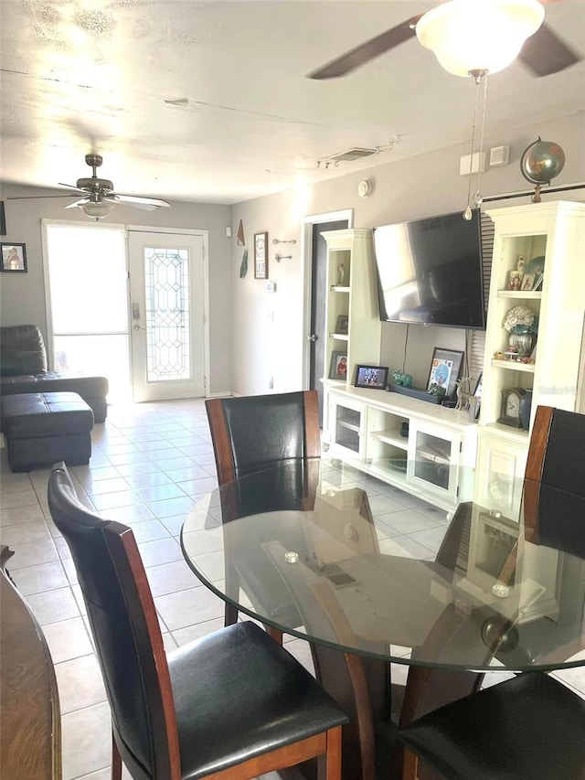 dining area with a ceiling fan and light tile patterned flooring