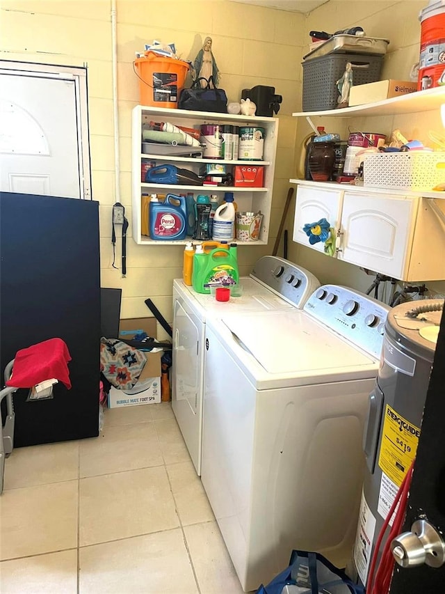 washroom featuring laundry area, water heater, light tile patterned flooring, and independent washer and dryer