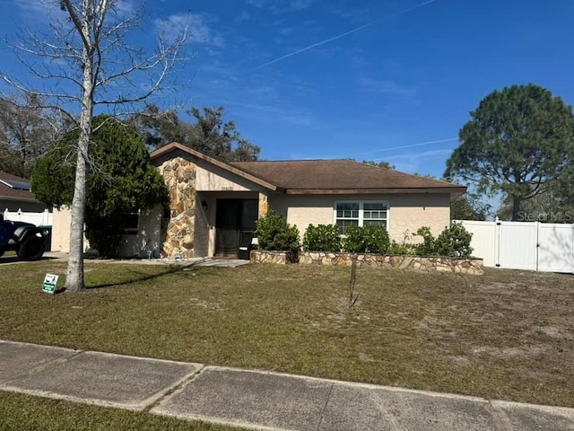 view of front facade featuring a front yard, fence, a gate, and stucco siding