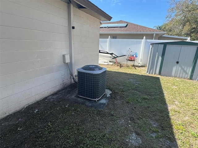 exterior space featuring central air condition unit, fence, and roof with shingles