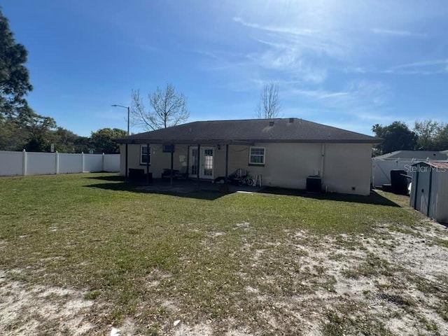 back of property featuring a patio area, a fenced backyard, a lawn, and central AC unit