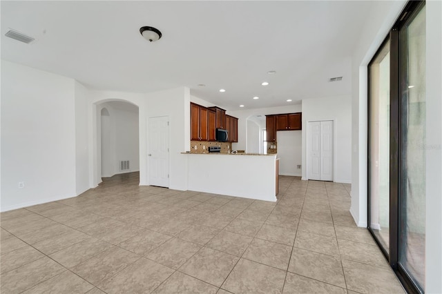 7108 Harvest Glen Ln, Riverview, FL 33578 - unfurnished living room with arched walkways, light tile patterned floors, recessed lighting, and baseboards