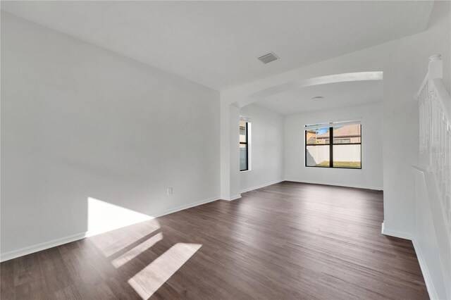 7108 Harvest Glen Ln, Riverview, FL 33578 - empty room featuring dark wood-style flooring, arched walkways, and baseboards