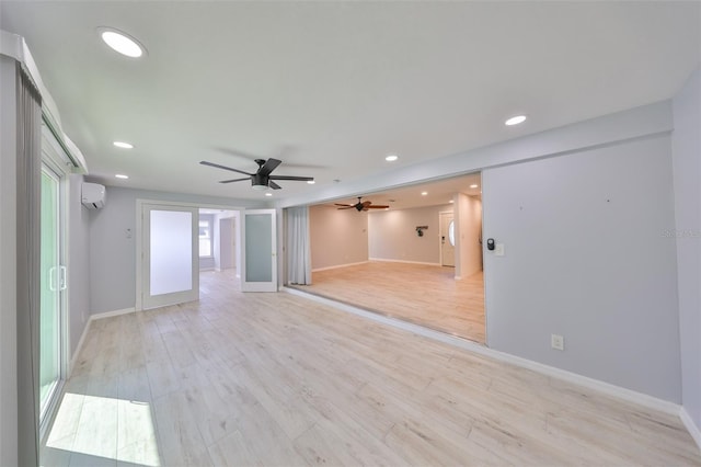 unfurnished room with baseboards, a ceiling fan, light wood-type flooring, a wall mounted AC, and recessed lighting