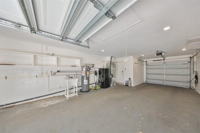 garage featuring water heater, a sink, and a garage door opener