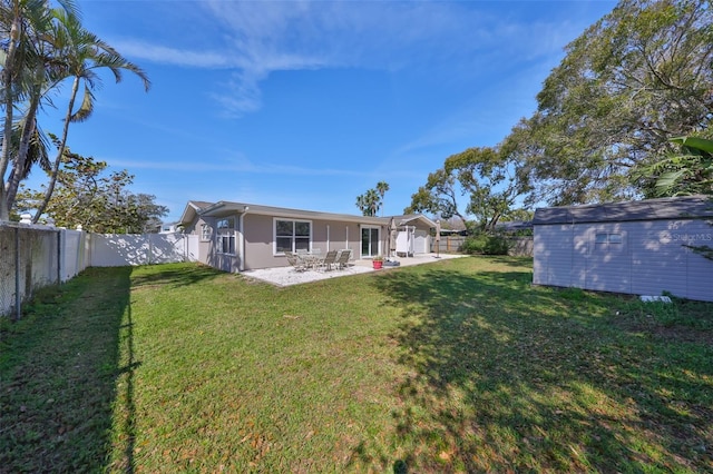 back of house featuring an outbuilding, a patio, a shed, and a fenced backyard