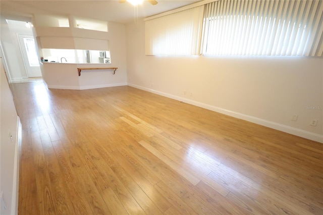 unfurnished living room with baseboards and light wood-style floors