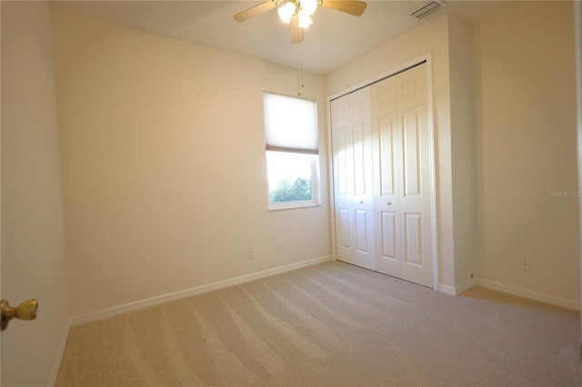 unfurnished bedroom featuring baseboards, visible vents, a closet, and light colored carpet