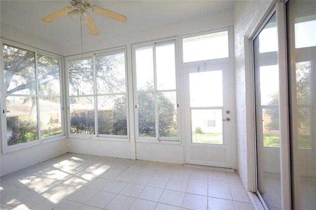 unfurnished sunroom featuring ceiling fan