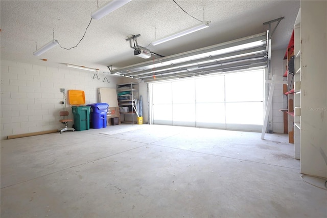 garage with concrete block wall and a garage door opener