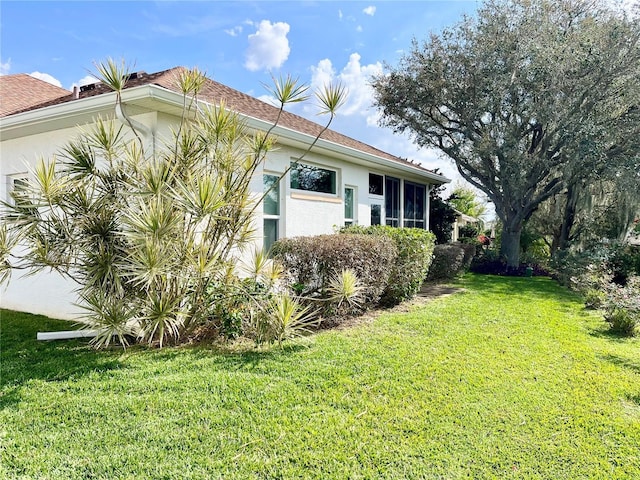 view of home's exterior featuring a yard and stucco siding