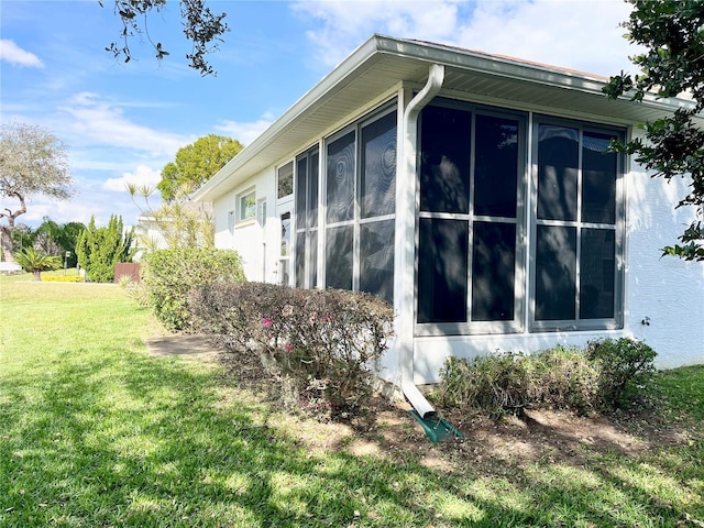 view of side of home with a lawn and a sunroom