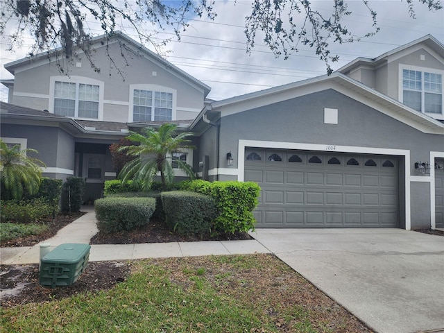 view of front of house with a garage, driveway, and stucco siding