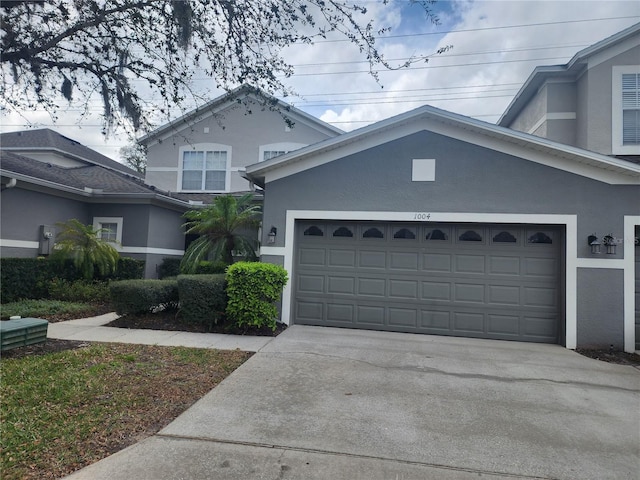 view of front of property featuring a garage, driveway, and stucco siding