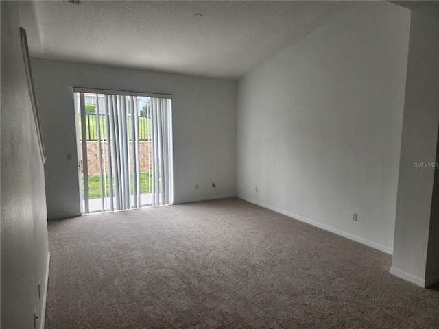 empty room with carpet floors, baseboards, and a textured ceiling